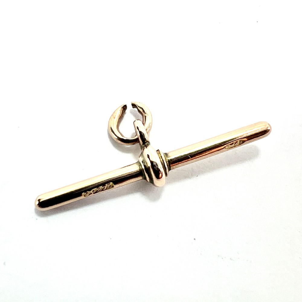 A polished 9ct rose gold Victorian albert T-bar pendant features a central crossbar and an attached jump ring. View II