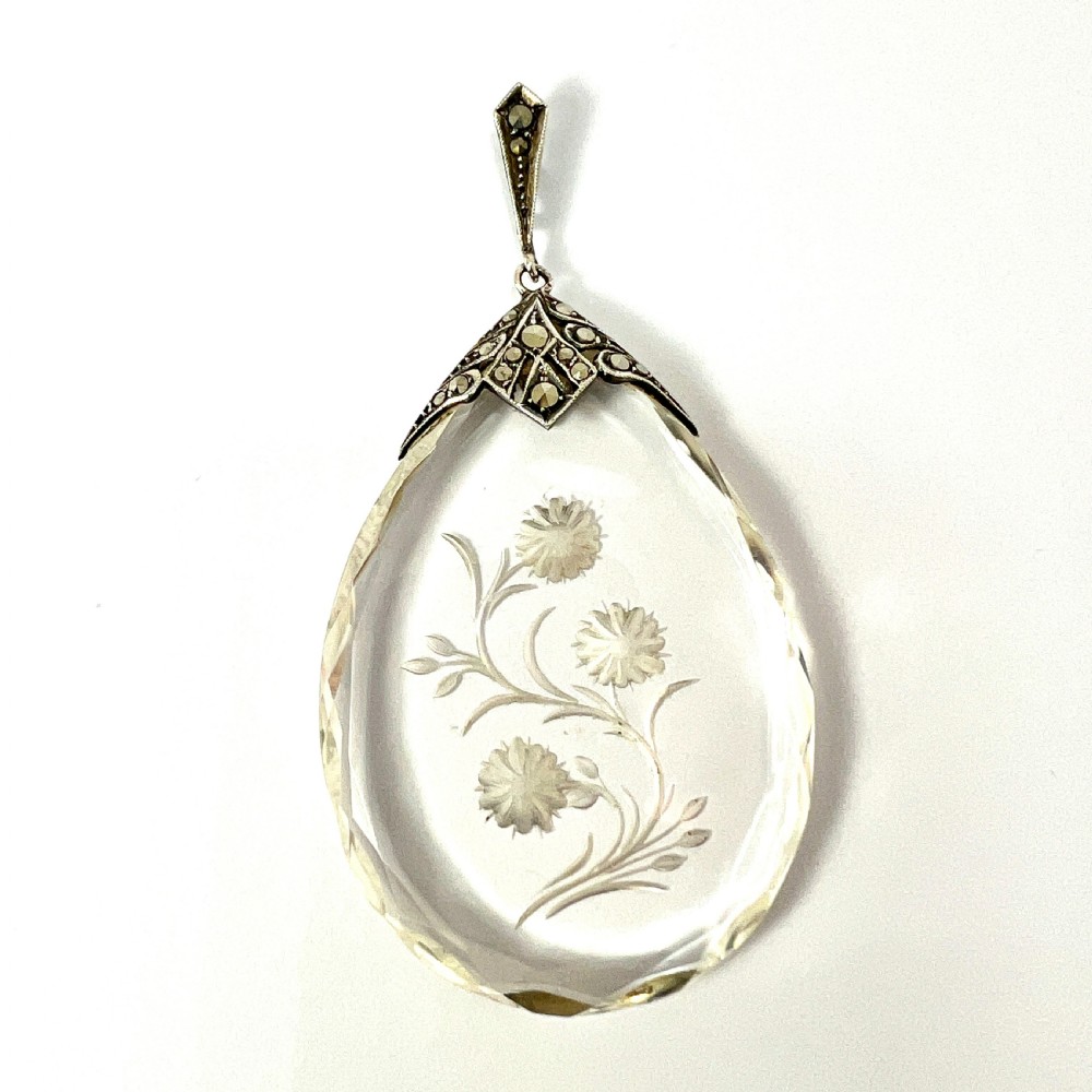 A clear glass teardrop pendant reverse-engraved with a floral motif, topped with a silver decorative cap set with faceted marcasite stones. View II