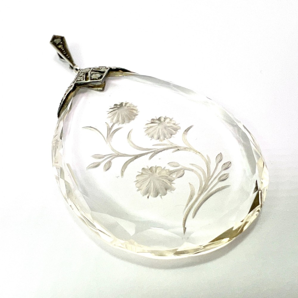 A clear glass teardrop pendant reverse-engraved with a floral motif, topped with a silver decorative cap set with faceted marcasite stones. View IV