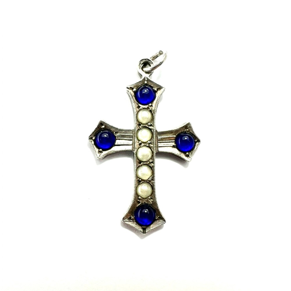 An antique sterling silver cross pendant set with blue paste cabochons and central white pearls against a white background.