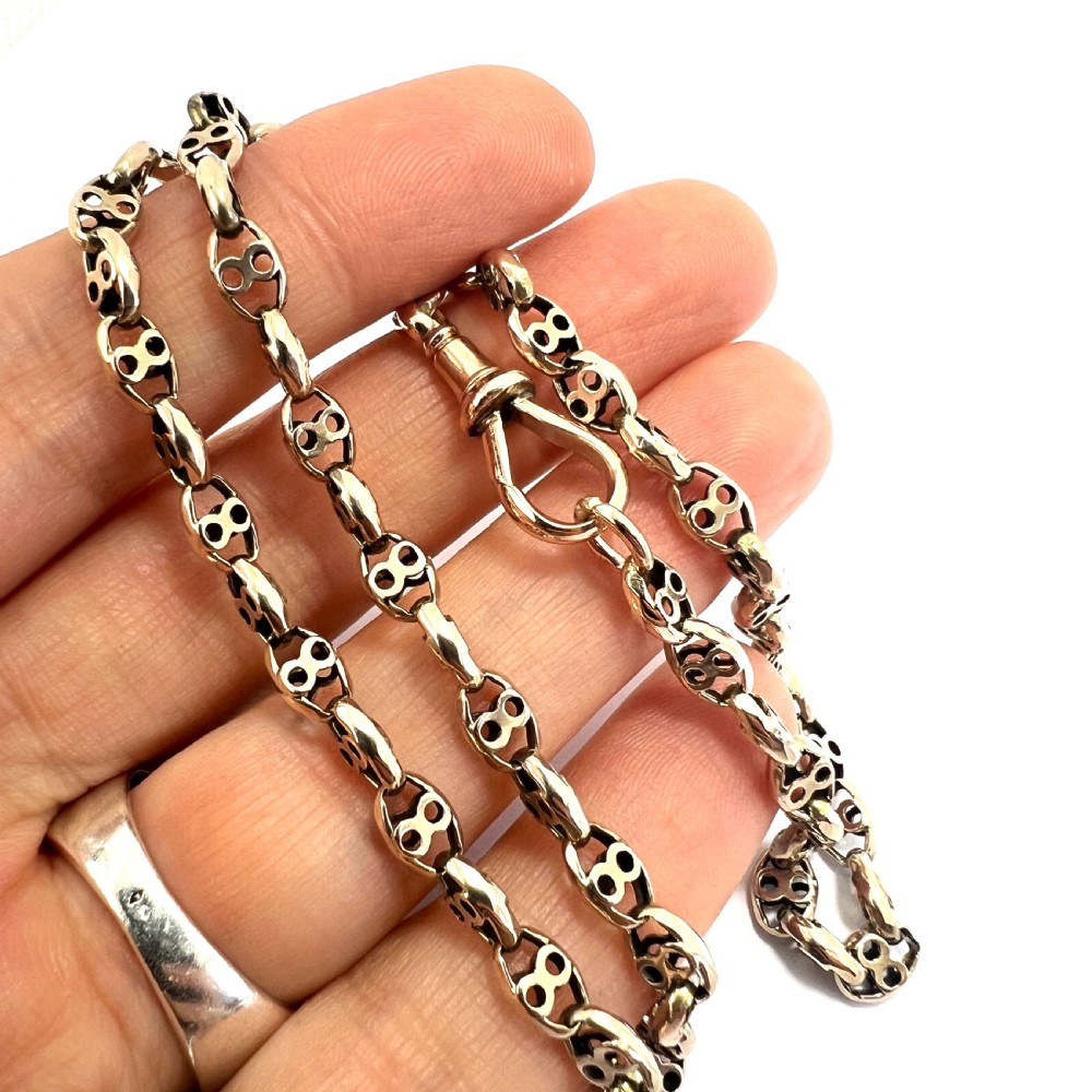 A coiled 9ct yellow gold Victorian fancy link albert chain featuring patterned open links and an attached swivel clip. View VIII