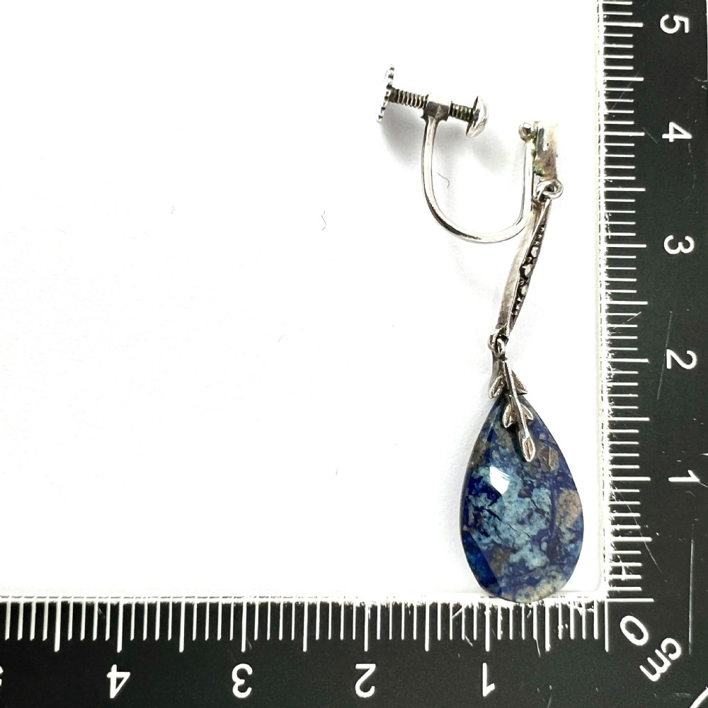 A pair of Art Deco silver screwback drop earrings featuring faceted blue teardrop stones suspended from linear marcasite-set bars. View IV
