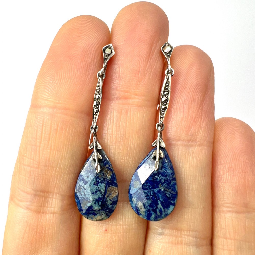 A pair of Art Deco silver screwback drop earrings featuring faceted blue teardrop stones suspended from linear marcasite-set bars. View VI