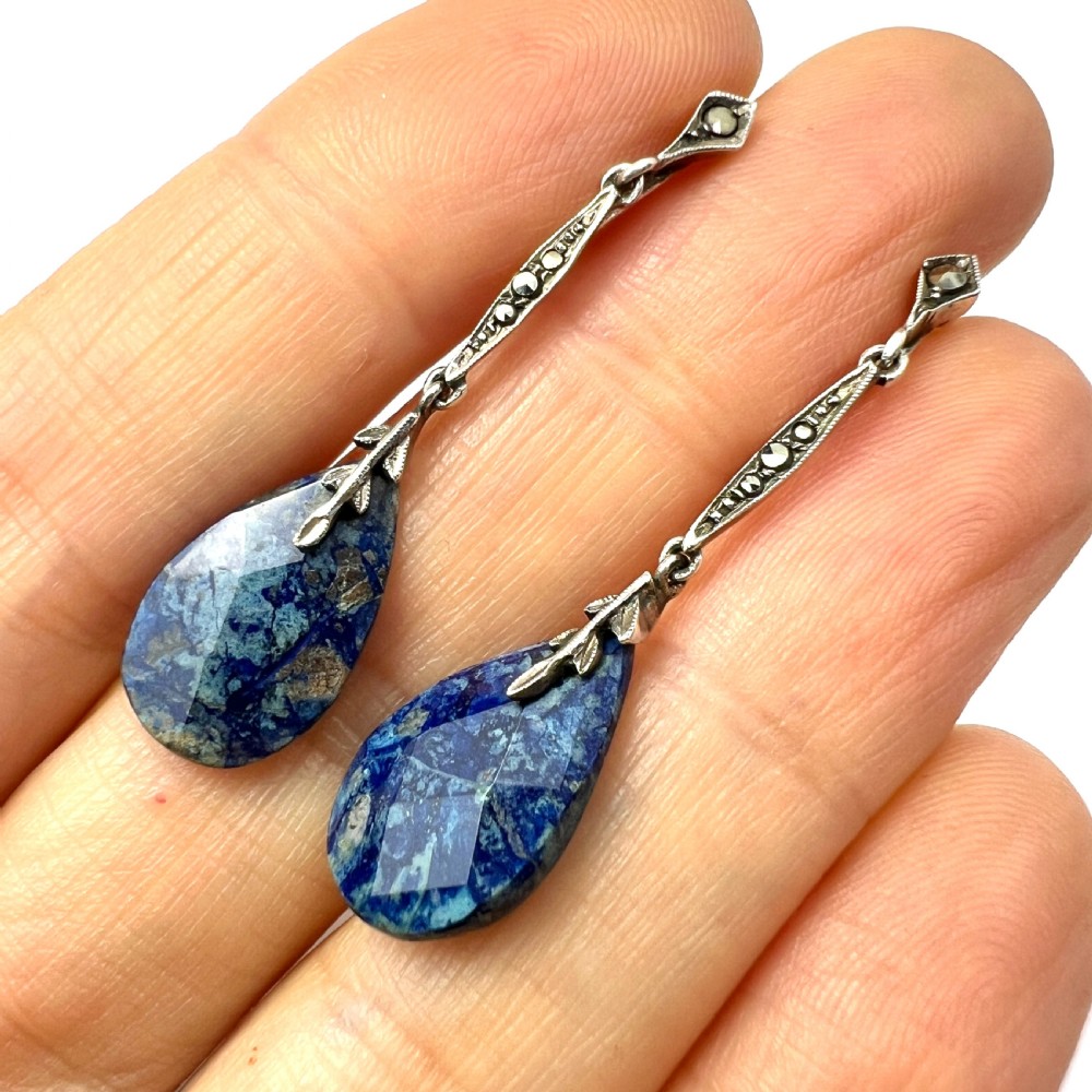 A pair of Art Deco silver screwback drop earrings featuring faceted blue teardrop stones suspended from linear marcasite-set bars. View VII