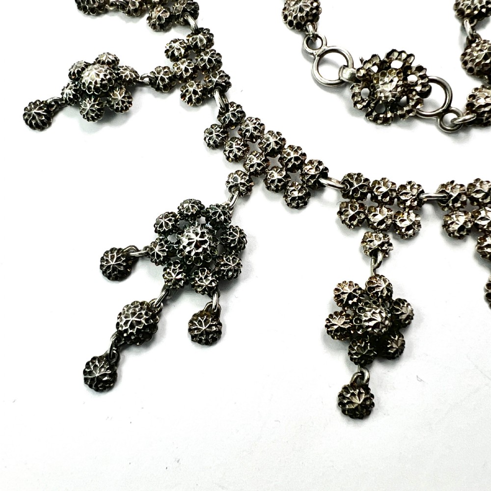 Victorian sterling silver necklace featuring textured spherical links and suspended chandelier drop motifs against a white backdrop. View III