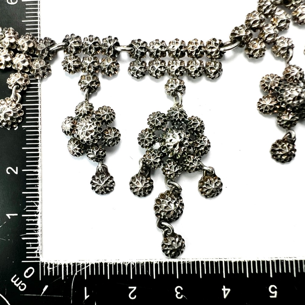 Victorian sterling silver necklace featuring textured spherical links and suspended chandelier drop motifs against a white backdrop. View VIII