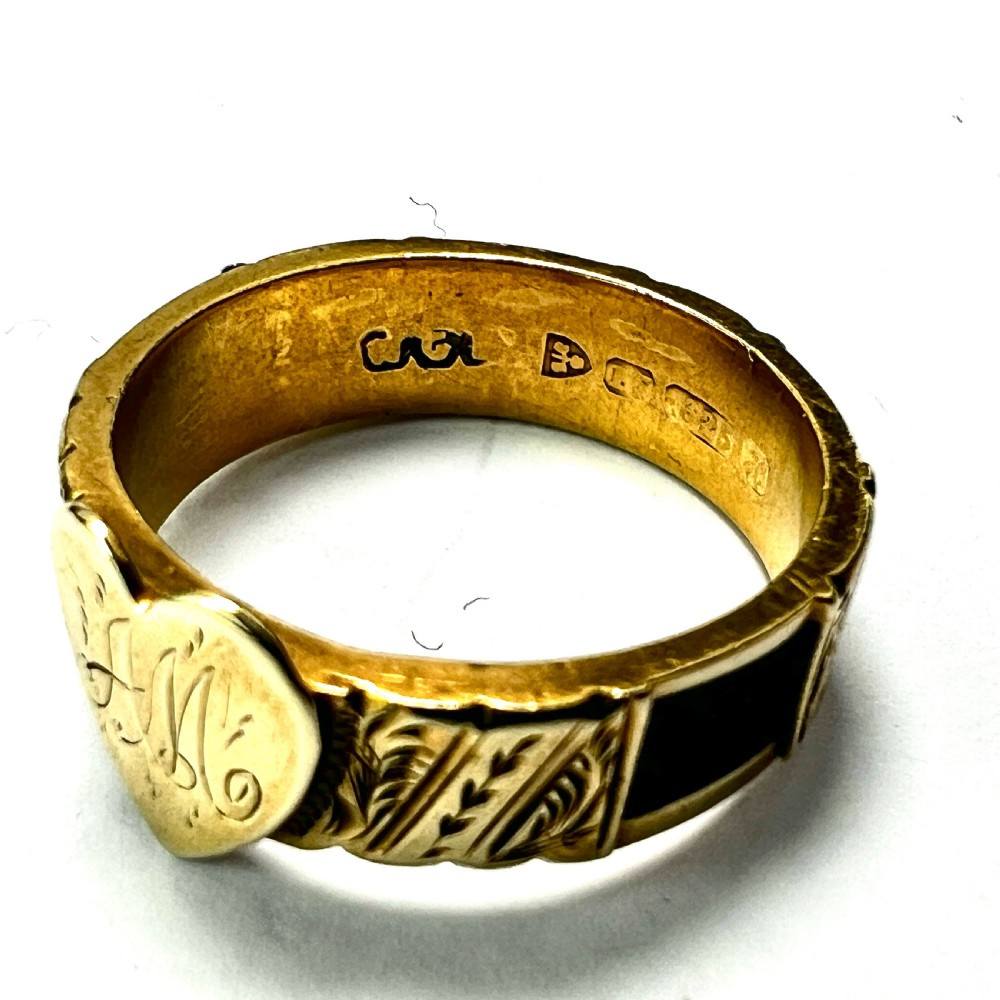 An Edwardian yellow gold ring featuring a central heart motif engraved with a monogram and shoulders decorated with chased scroll patterns. View II