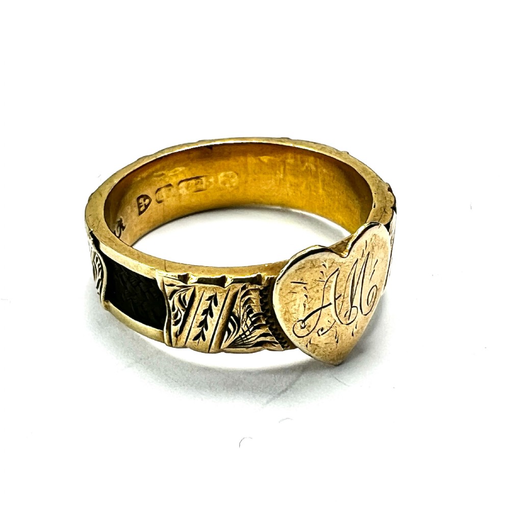 An Edwardian yellow gold ring featuring a central heart motif engraved with a monogram and shoulders decorated with chased scroll patterns. View III