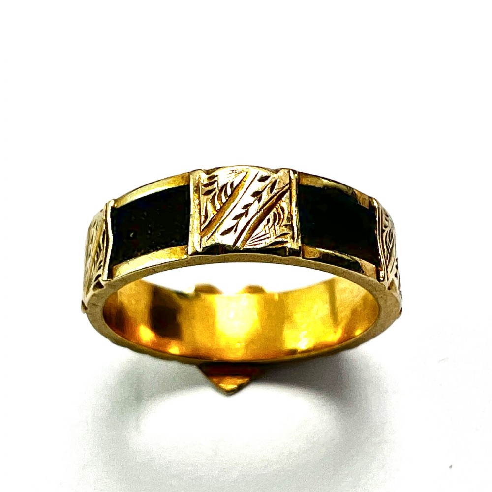 An Edwardian yellow gold ring featuring a central heart motif engraved with a monogram and shoulders decorated with chased scroll patterns. View IV