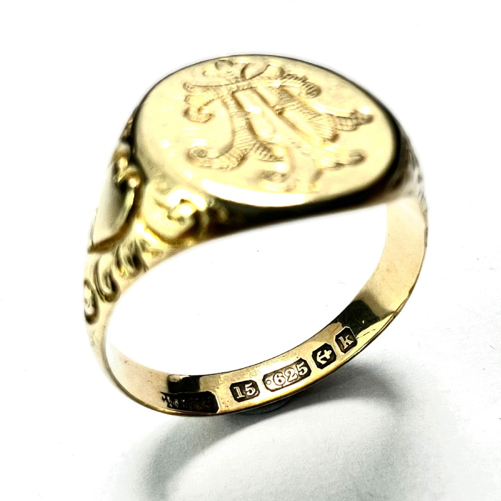 An antique yellow gold signet ring featuring an oval head with a hand-engraved monogram and detailed heart motifs on the shoulders. View IV