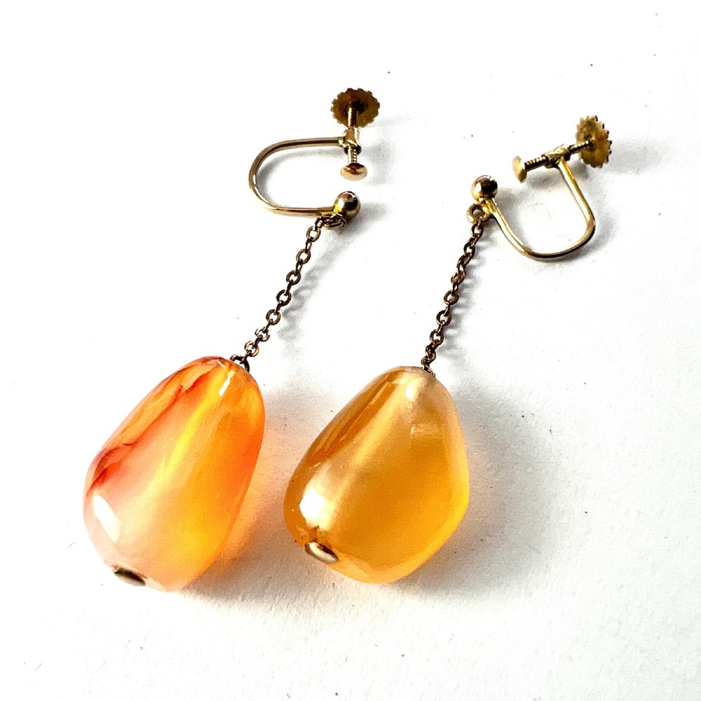 A pair of antique nine-carat gold screwback earrings featuring fine chain links suspending polished orange-toned agate teardrops. View II