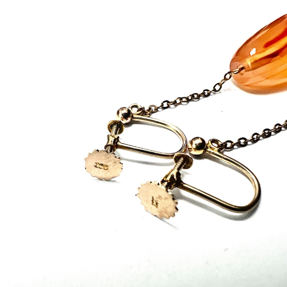 A pair of antique nine-carat gold screwback earrings featuring fine chain links suspending polished orange-toned agate teardrops. View VII