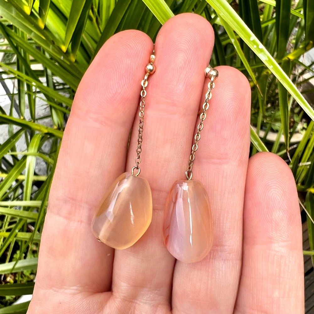 A pair of antique nine-carat gold screwback earrings featuring fine chain links suspending polished orange-toned agate teardrops. View IX