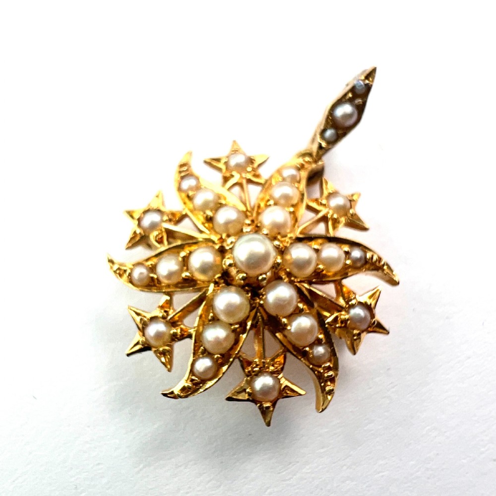 An antique 18ct yellow gold sunburst pendant brooch embellished with central and accent pearls arranged in a celestial motif with an attached pearl-set bale. View II