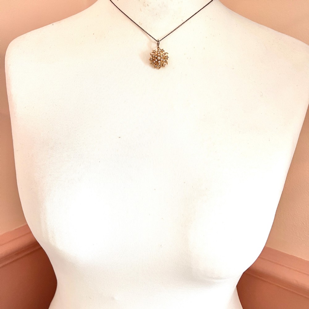 An antique 18ct yellow gold sunburst pendant brooch embellished with central and accent pearls arranged in a celestial motif with an attached pearl-set bale. View V