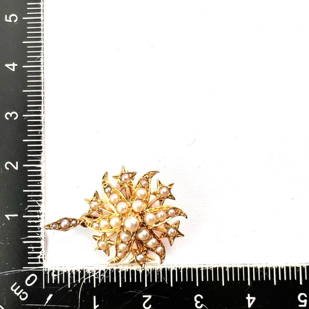 An antique 18ct yellow gold sunburst pendant brooch embellished with central and accent pearls arranged in a celestial motif with an attached pearl-set bale. View VI