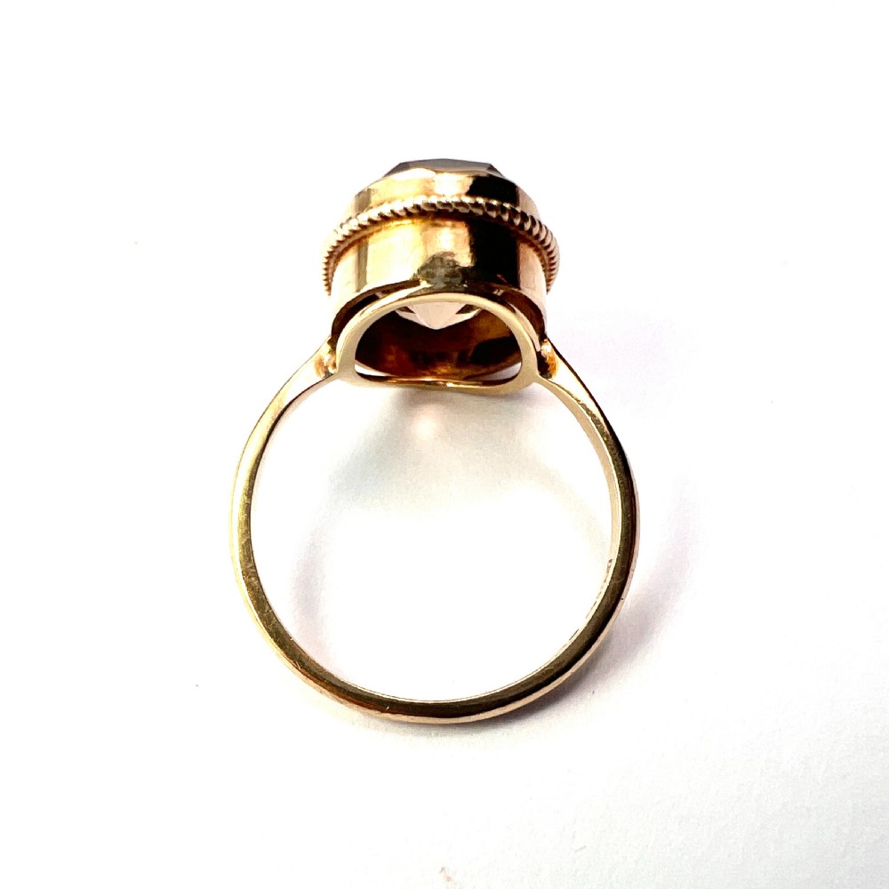 A vintage yellow gold ring set with a large oval faceted translucent brown smoky quartz stone framed by a twisted rope bezel detail. View VII