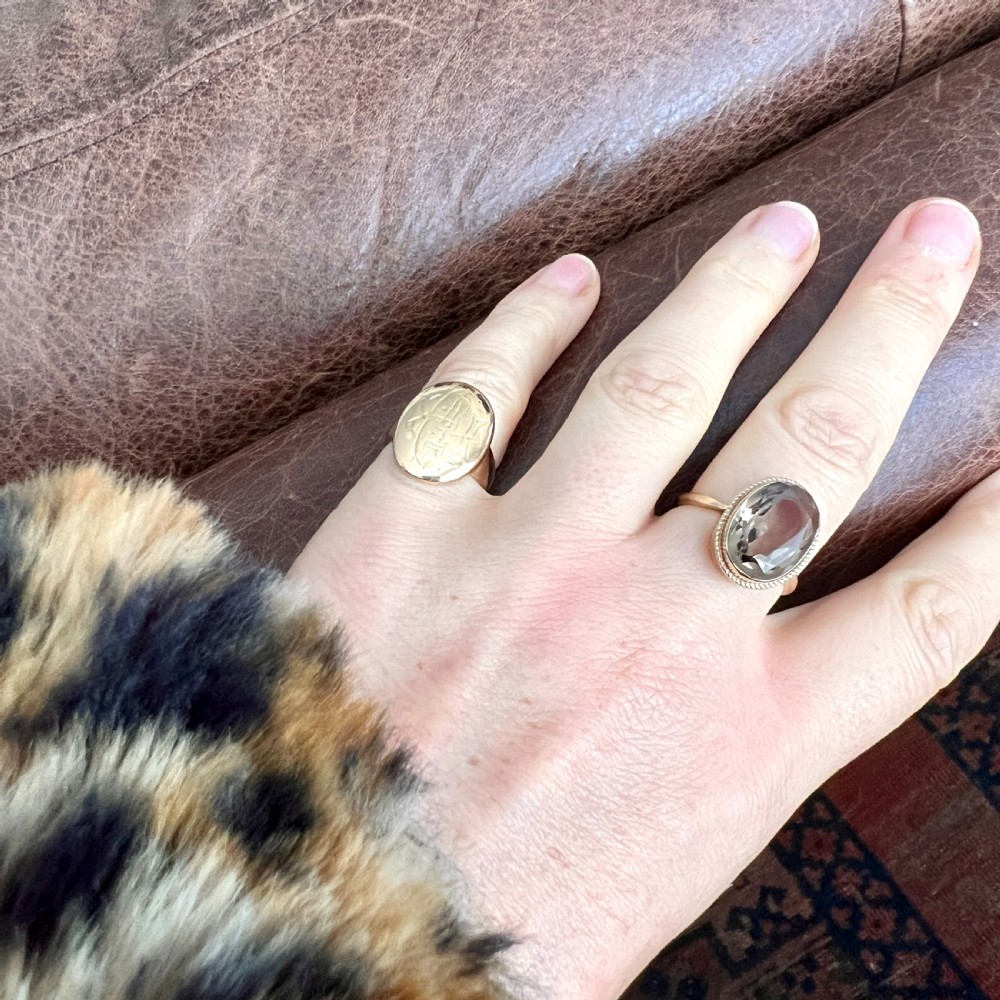 A vintage yellow gold ring set with a large oval faceted translucent brown smoky quartz stone framed by a twisted rope bezel detail. View VIII