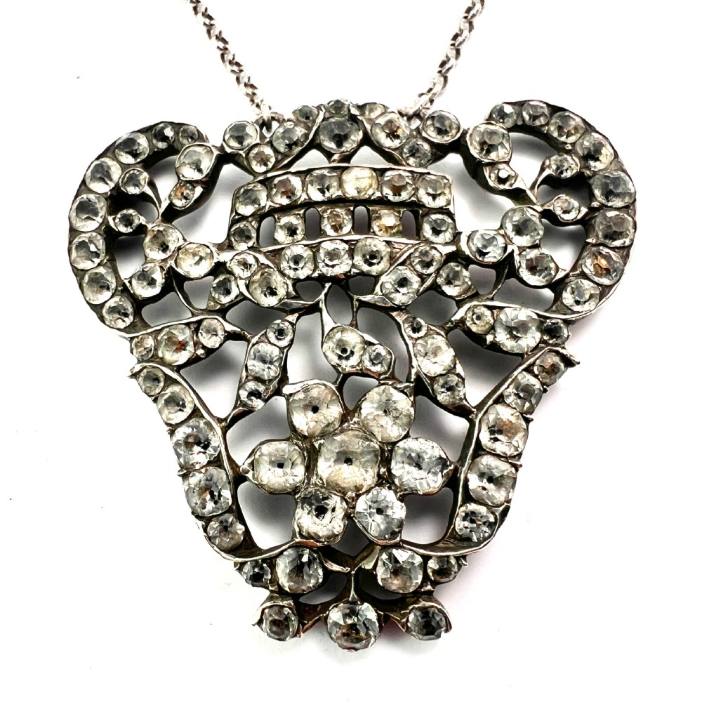 An intricate openwork Georgian silver pendant set with faceted clear black dot paste stones on a silver chain. View III
