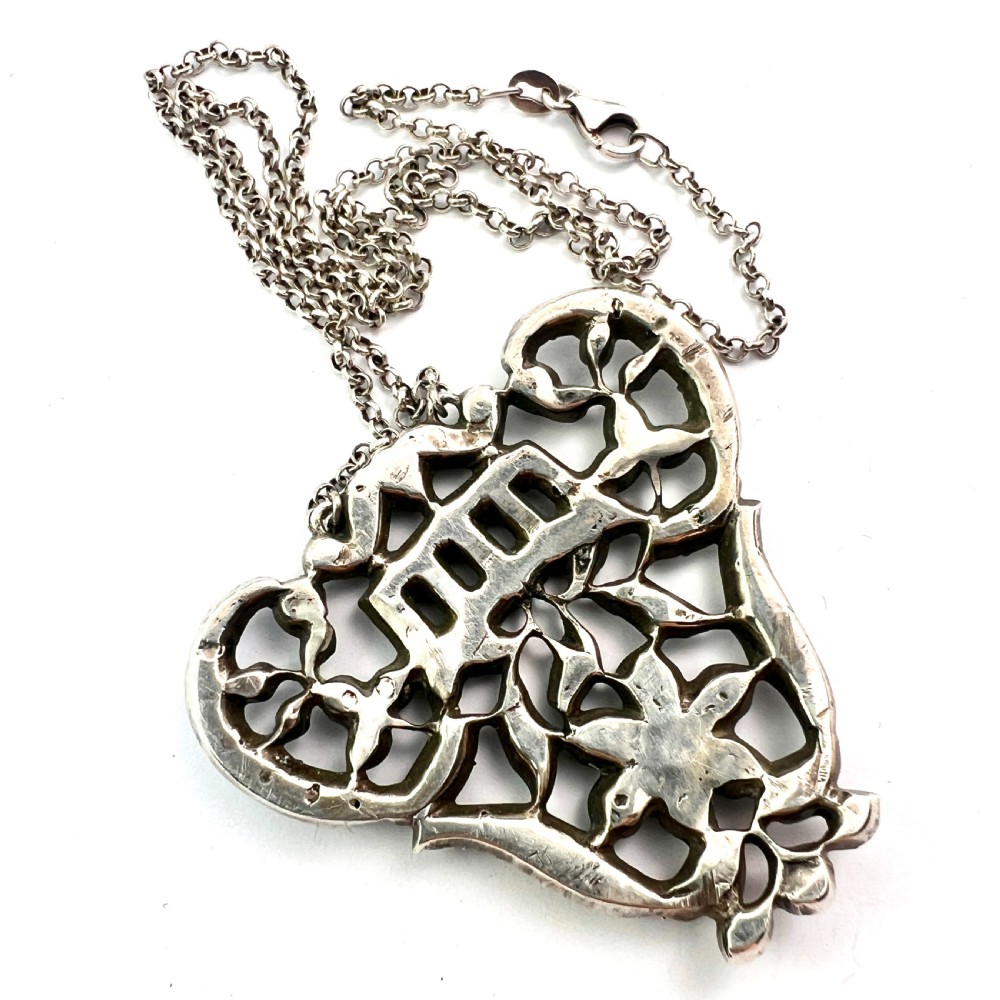 An intricate openwork Georgian silver pendant set with faceted clear black dot paste stones on a silver chain. View V