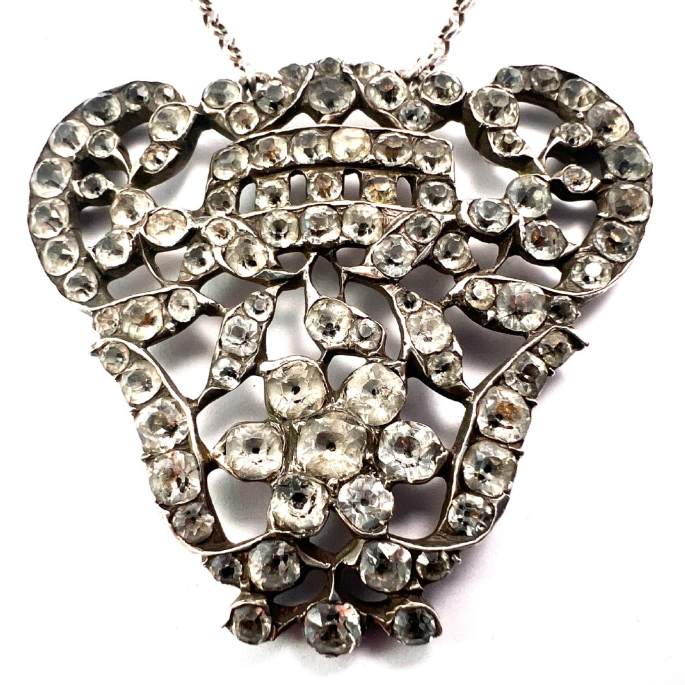 An intricate openwork Georgian silver pendant set with faceted clear black dot paste stones on a silver chain. View VI