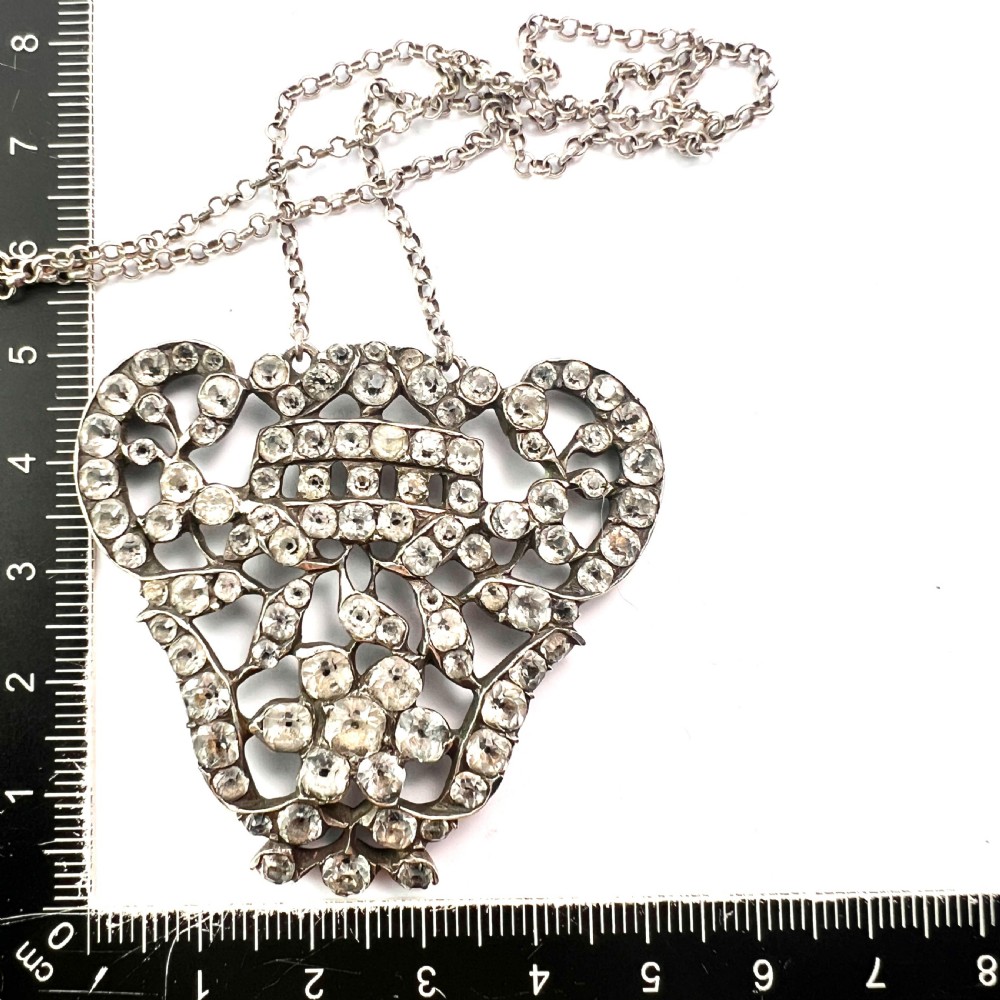 An intricate openwork Georgian silver pendant set with faceted clear black dot paste stones on a silver chain. View VII