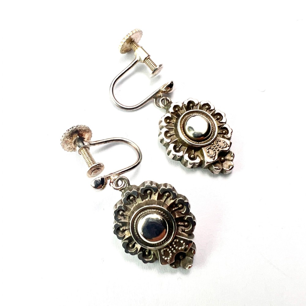 A pair of silver Victorian Aesthetic Era drop earrings featuring a sunburst motif with beaded detailing and screwback fastenings. View II