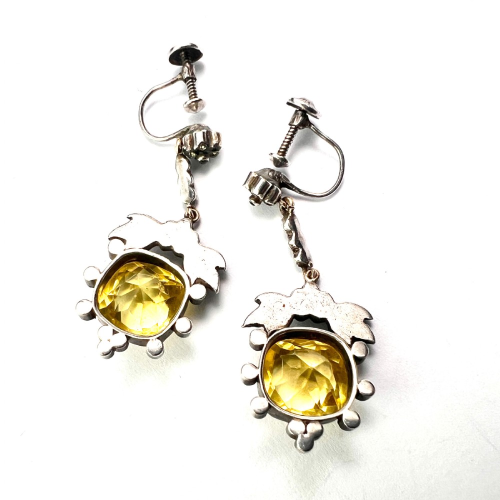 A pair of Victorian silver drop earrings featuring cushion-cut yellow citrine paste stones surrounded by foliate settings with clear glass accents. View VIII
