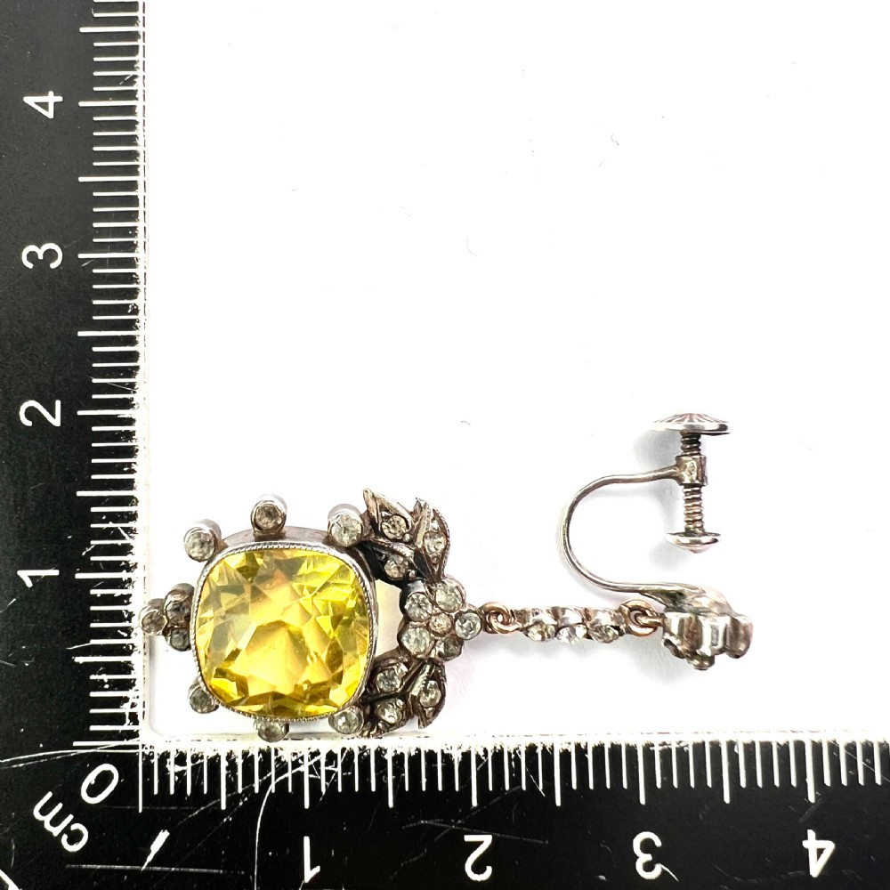 A pair of Victorian silver drop earrings featuring cushion-cut yellow citrine paste stones surrounded by foliate settings with clear glass accents. View IX