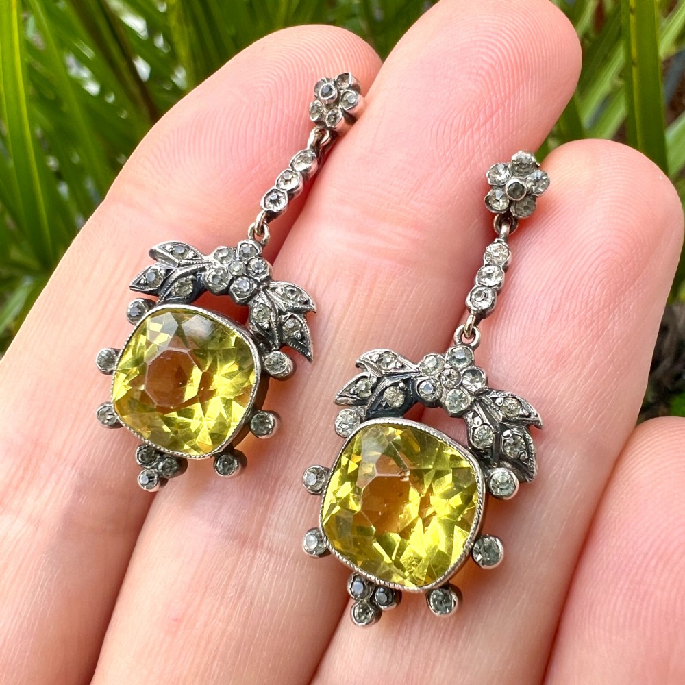 A pair of Victorian silver drop earrings featuring cushion-cut yellow citrine paste stones surrounded by foliate settings with clear glass accents. View XI