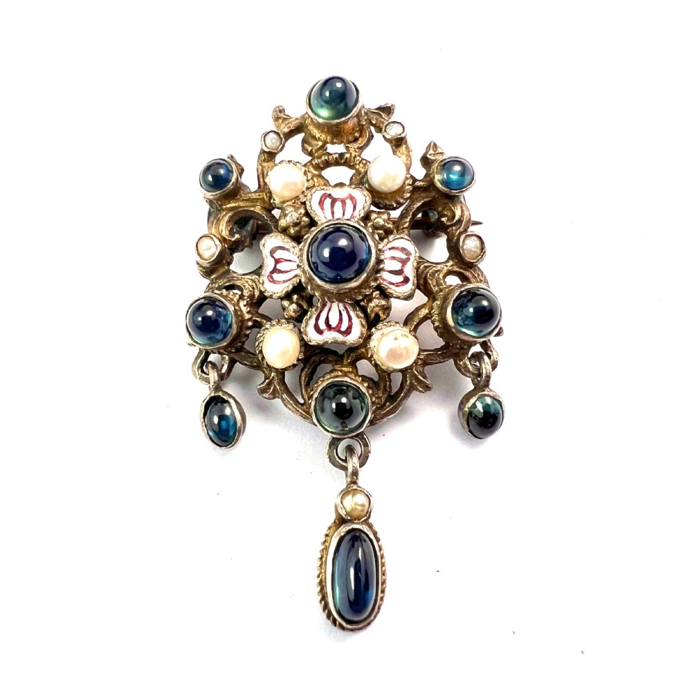 An Austro-Hungarian silver-gilt brooch decorated with blue cabochons, seed pearls, polychrome enamel, and a dangling teardrop pendant. View III