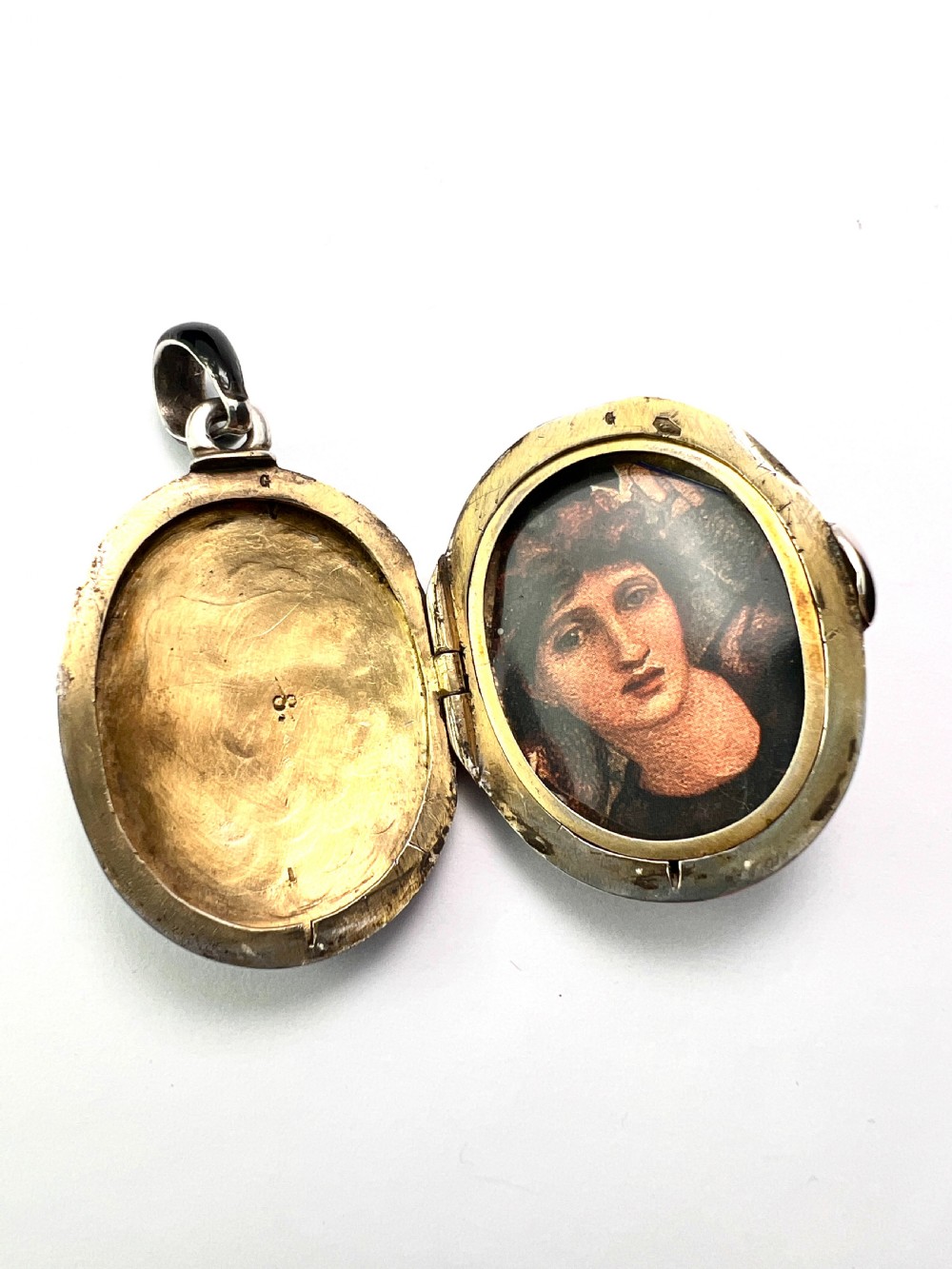 An oval Victorian silver locket rendered in black enamel with an intricate marcasite-set AEI monogram on the front surface. View VIII