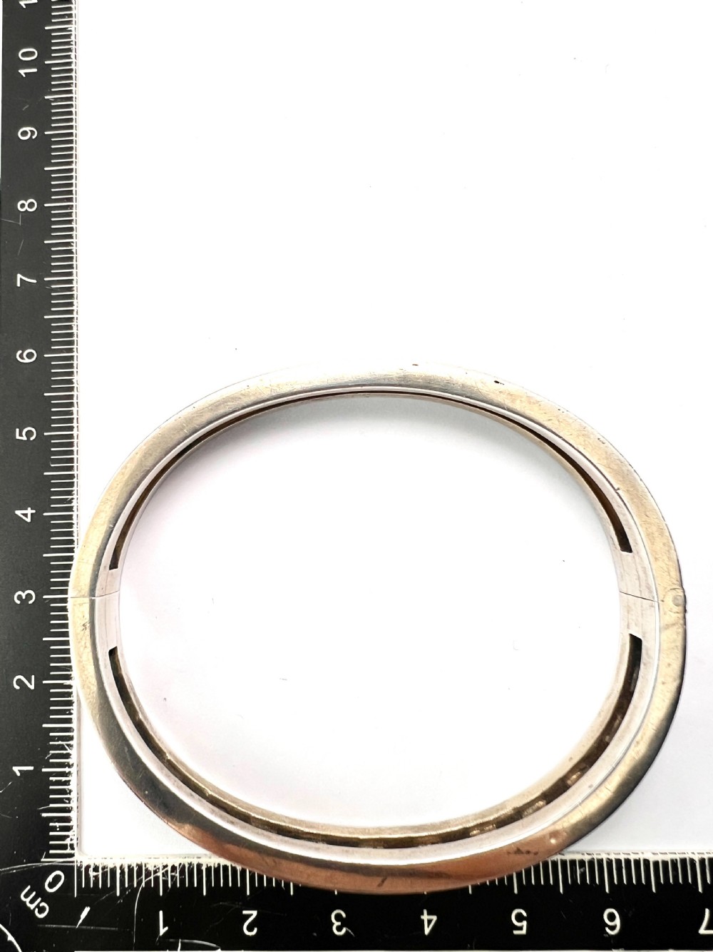 An antique Austro-Hungarian silver hinged bangle featuring black enamel borders and an openwork centre set with seed pearls. View VI