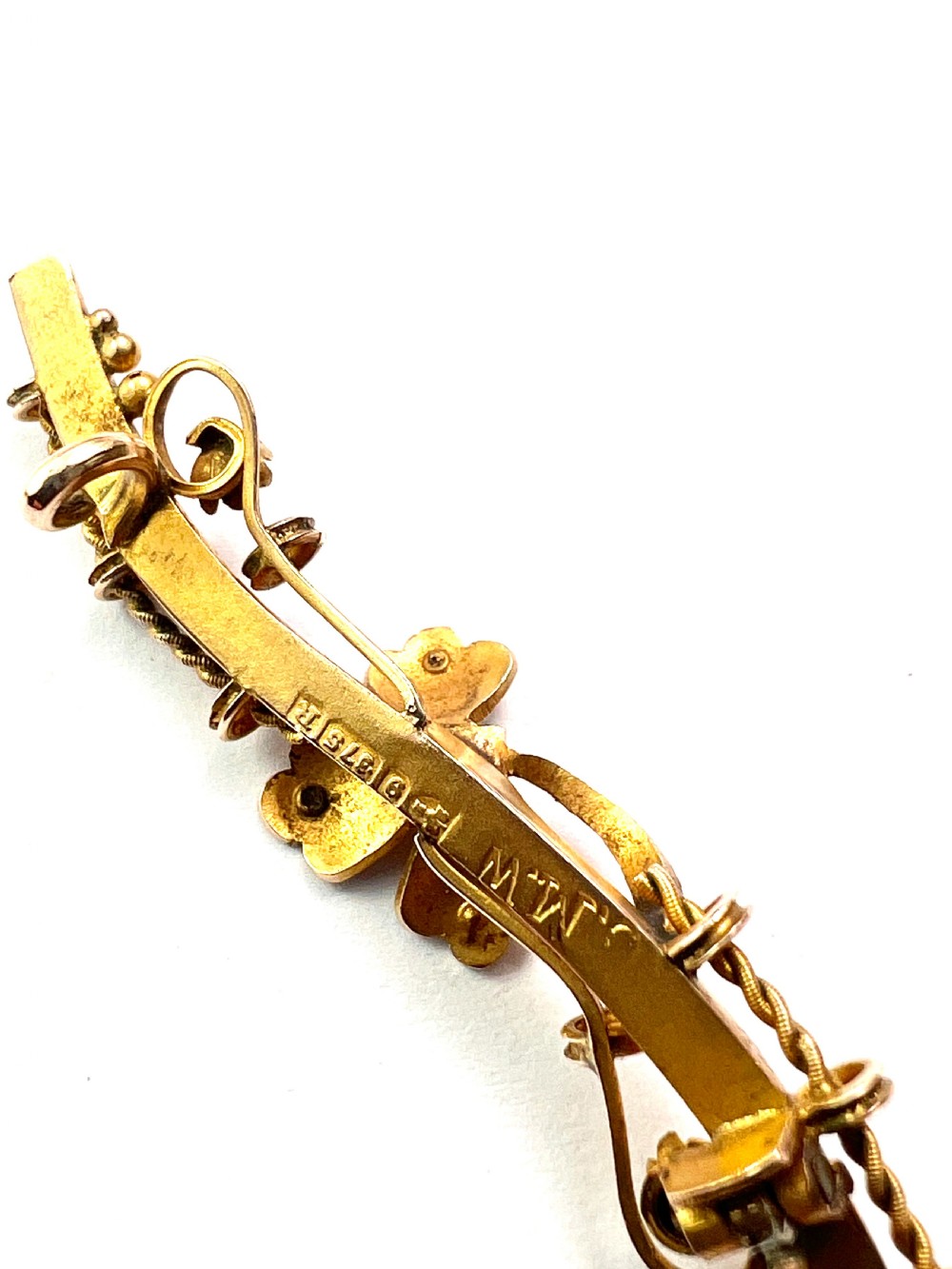 A Victorian 9ct yellow gold bar brooch featuring a central three-leaf clover set with a cabochon opal and accent diamonds. View IV