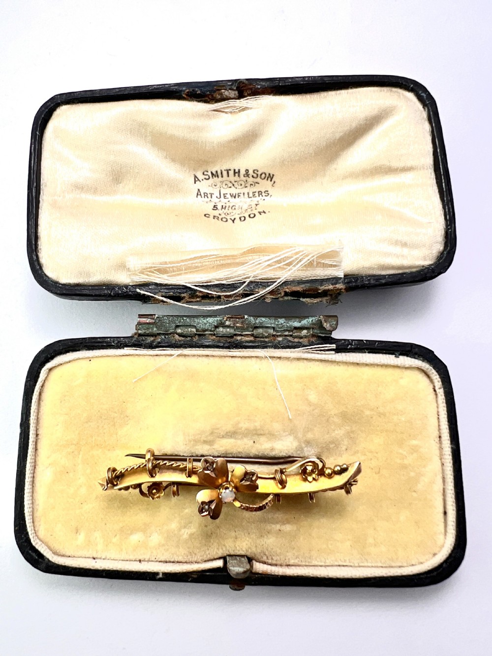 A Victorian 9ct yellow gold bar brooch featuring a central three-leaf clover set with a cabochon opal and accent diamonds. View XII