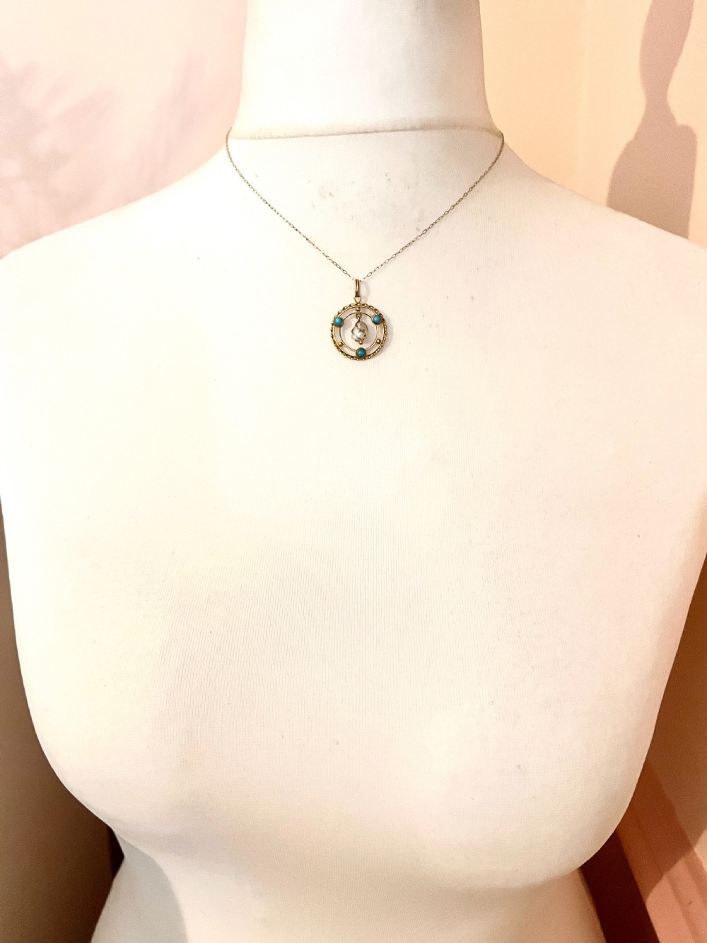 A circular 15ct yellow gold Edwardian pendant set with three turquoise cabochons and a central wire-wrapped baroque pearl. View VII