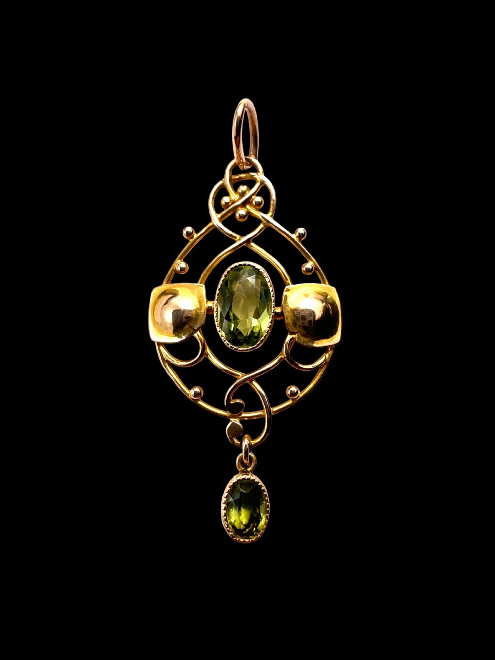 An Edwardian 15ct gold Art Nouveau openwork pendant set with two faceted green peridot gemstones. View II