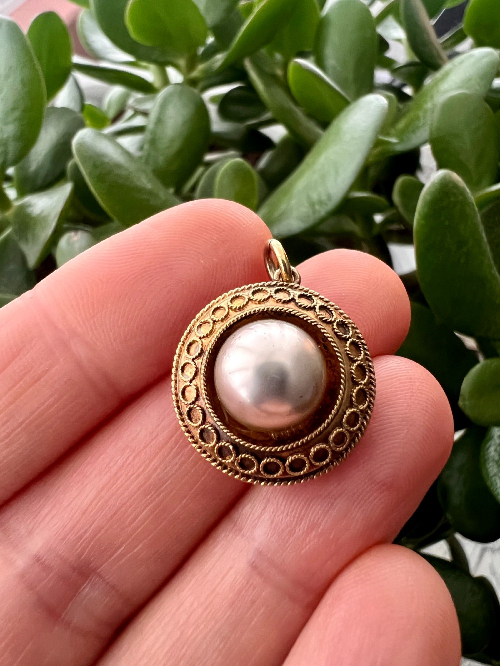 A circular Victorian yellow gold pendant featuring a large central pearl bordered by intricate filigree wirework and ropework detail. View VIII