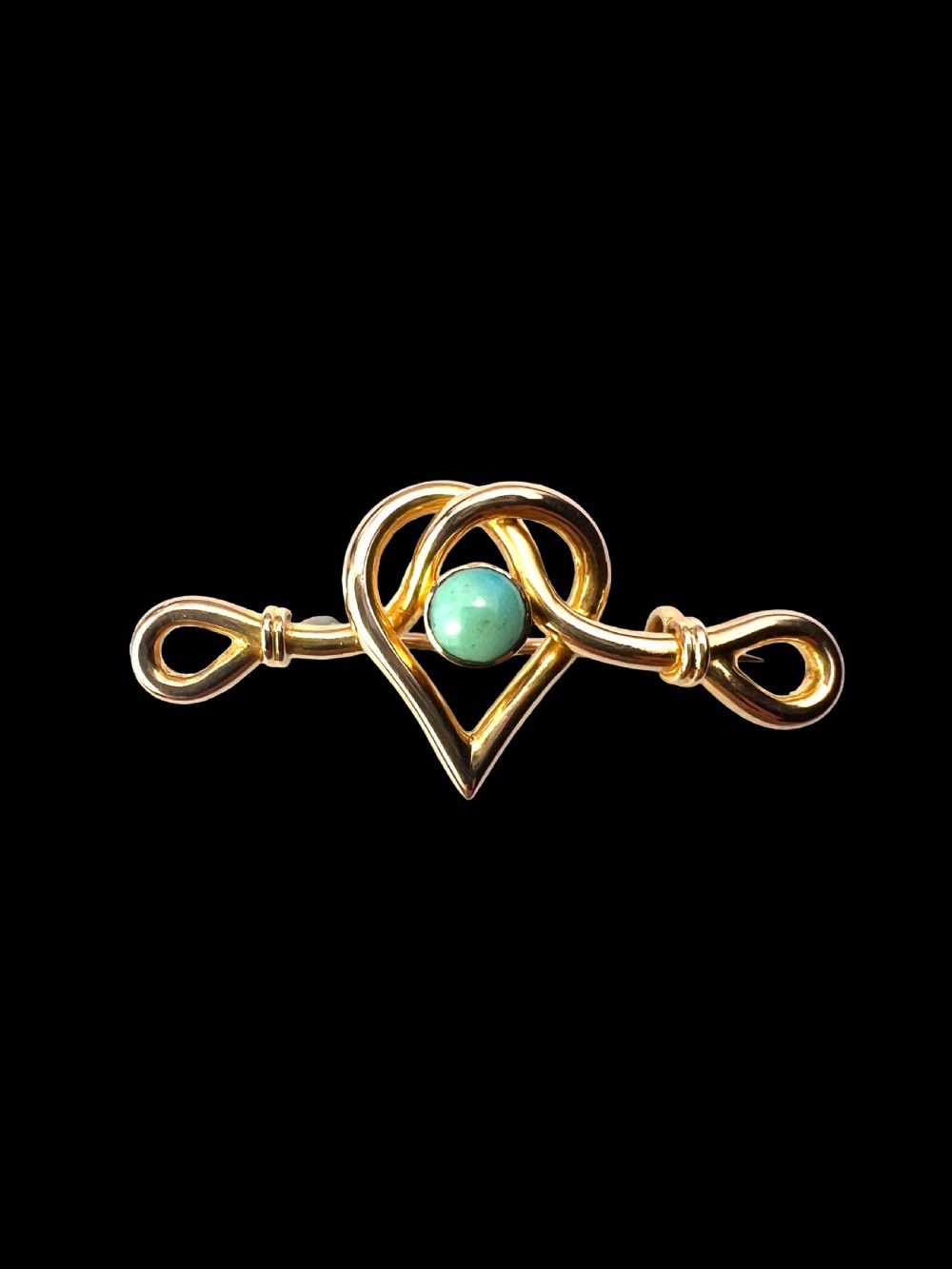 An antique 15ct yellow gold bar brooch featuring a central entwined heart motif set with a round turquoise cabochon stone. View II