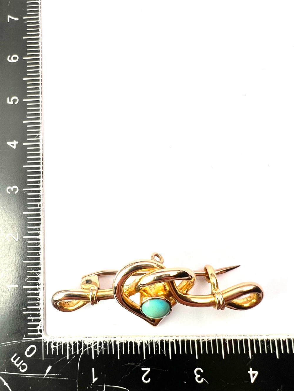 An antique 15ct yellow gold bar brooch featuring a central entwined heart motif set with a round turquoise cabochon stone. View VIII