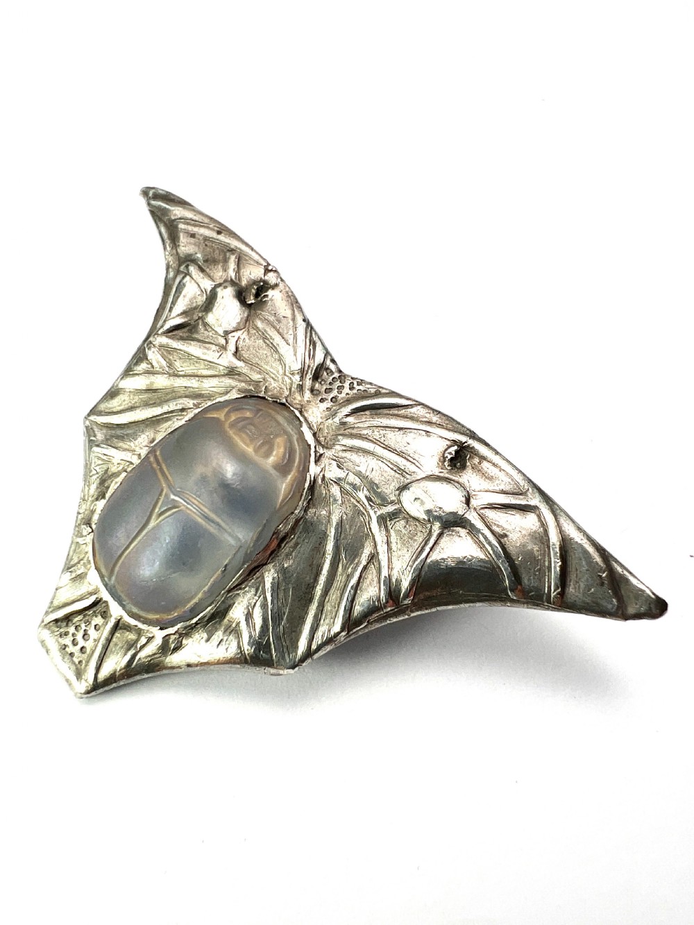 An antique pewter Art Nouveau brooch featuring a central translucent scarab beetle cabochon flanked by outstretched stylized wings. View II