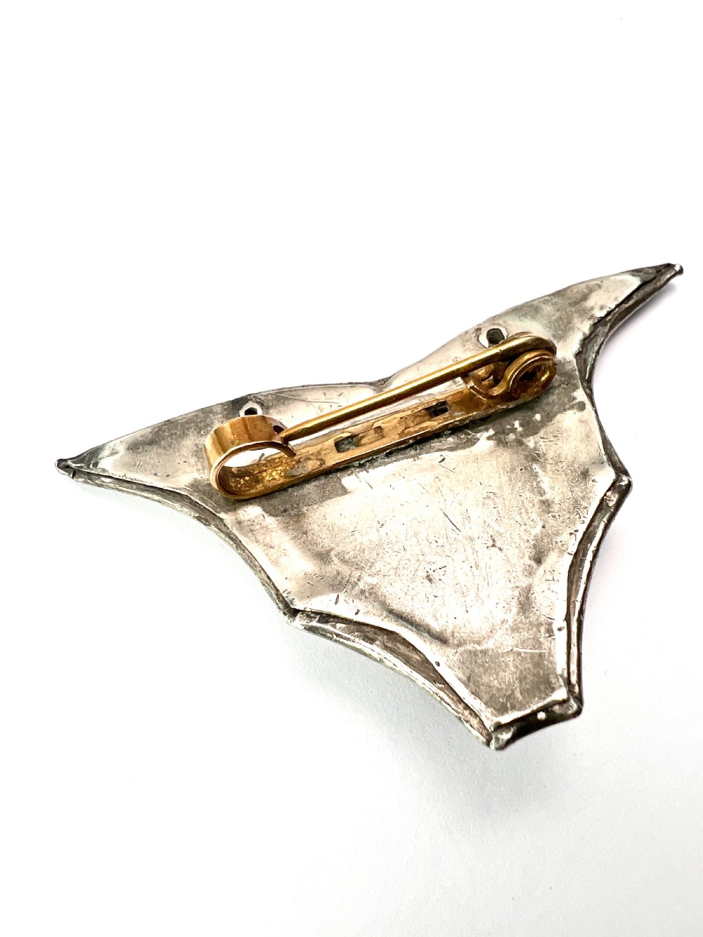 An antique pewter Art Nouveau brooch featuring a central translucent scarab beetle cabochon flanked by outstretched stylized wings. View IV