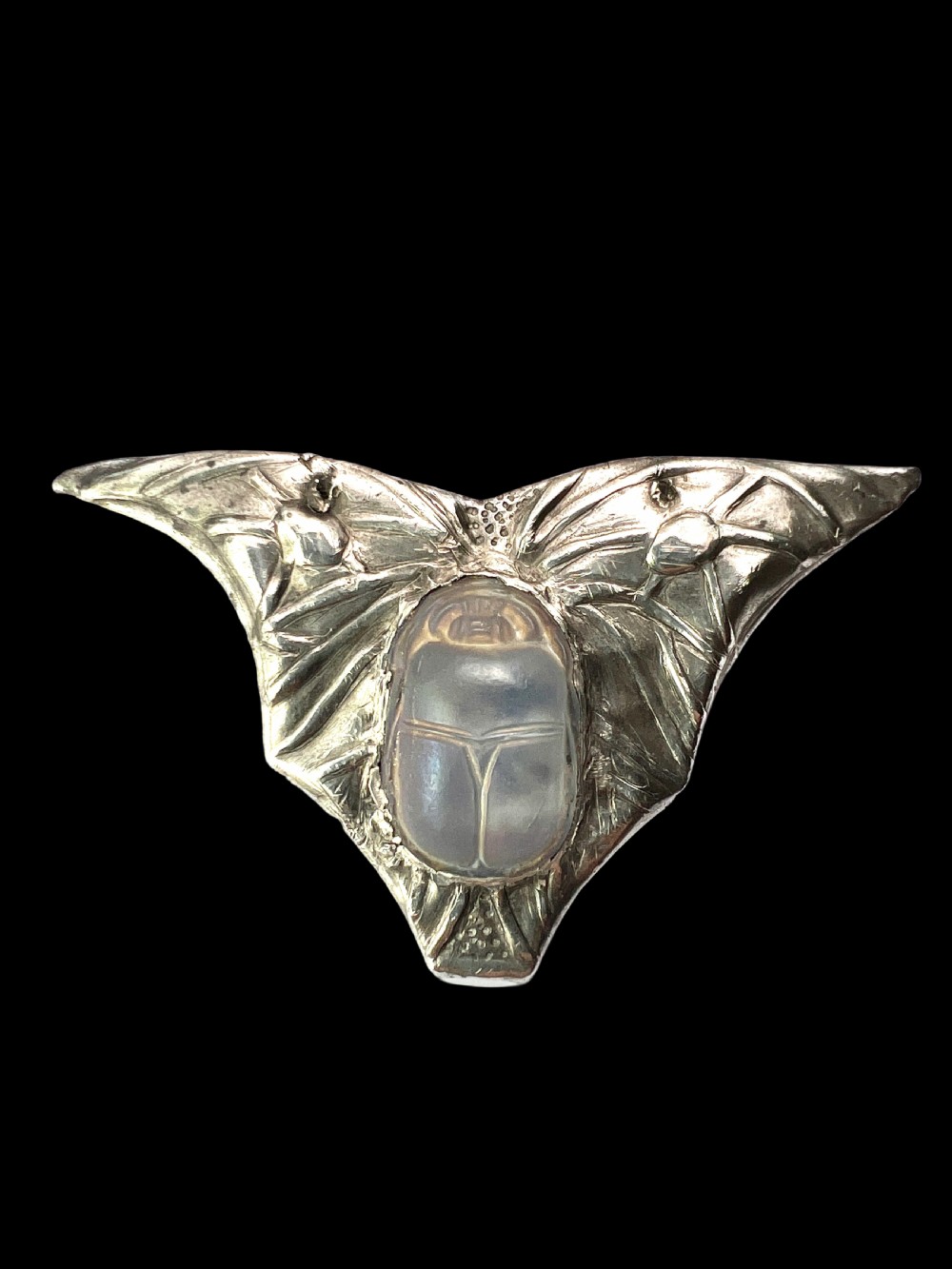 An antique pewter Art Nouveau brooch featuring a central translucent scarab beetle cabochon flanked by outstretched stylized wings. View V