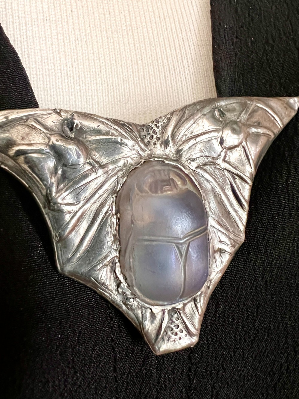 An antique pewter Art Nouveau brooch featuring a central translucent scarab beetle cabochon flanked by outstretched stylized wings. View VI