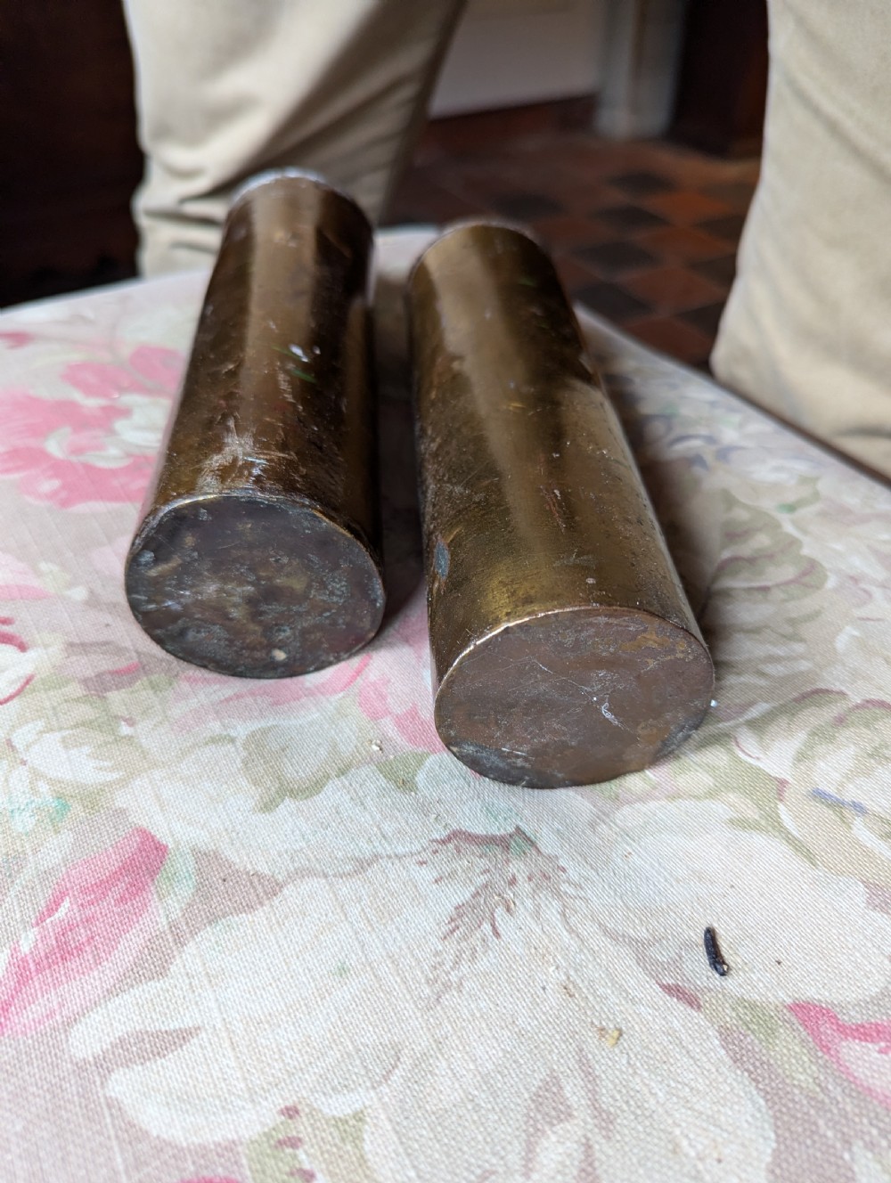 A pair of cylindrical eighteenth-century brass-cased longcase clock weights showing surface oxidation and original metal wear. View II