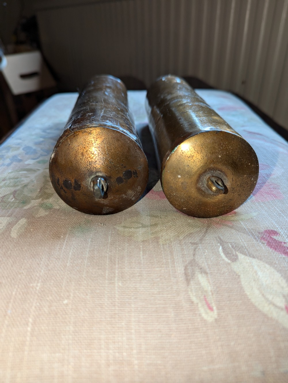 A pair of cylindrical eighteenth-century brass-cased longcase clock weights showing surface oxidation and original metal wear. View III