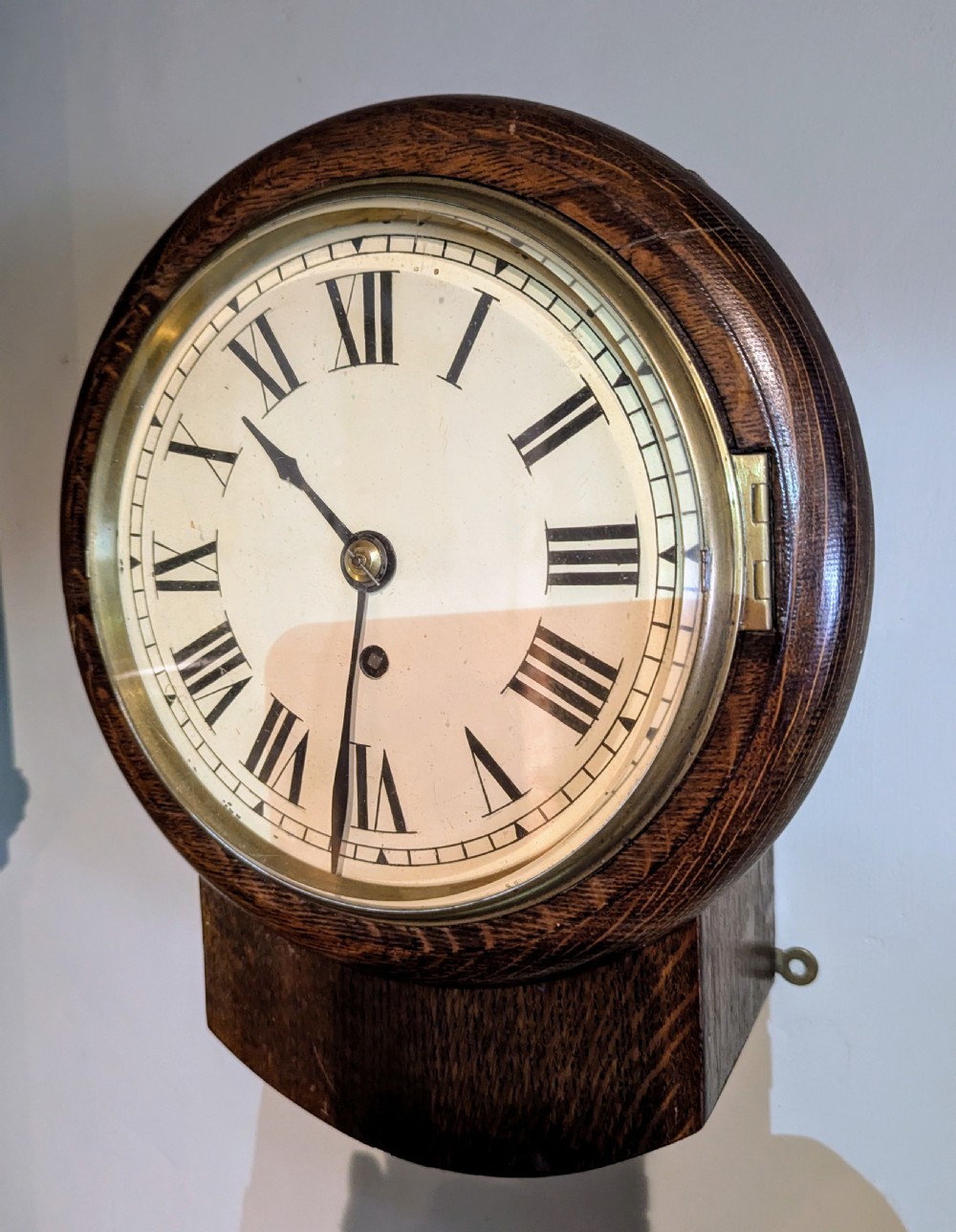 A late nineteenth-century circular oak fusee dial clock with a brass bezel and Roman numerals.