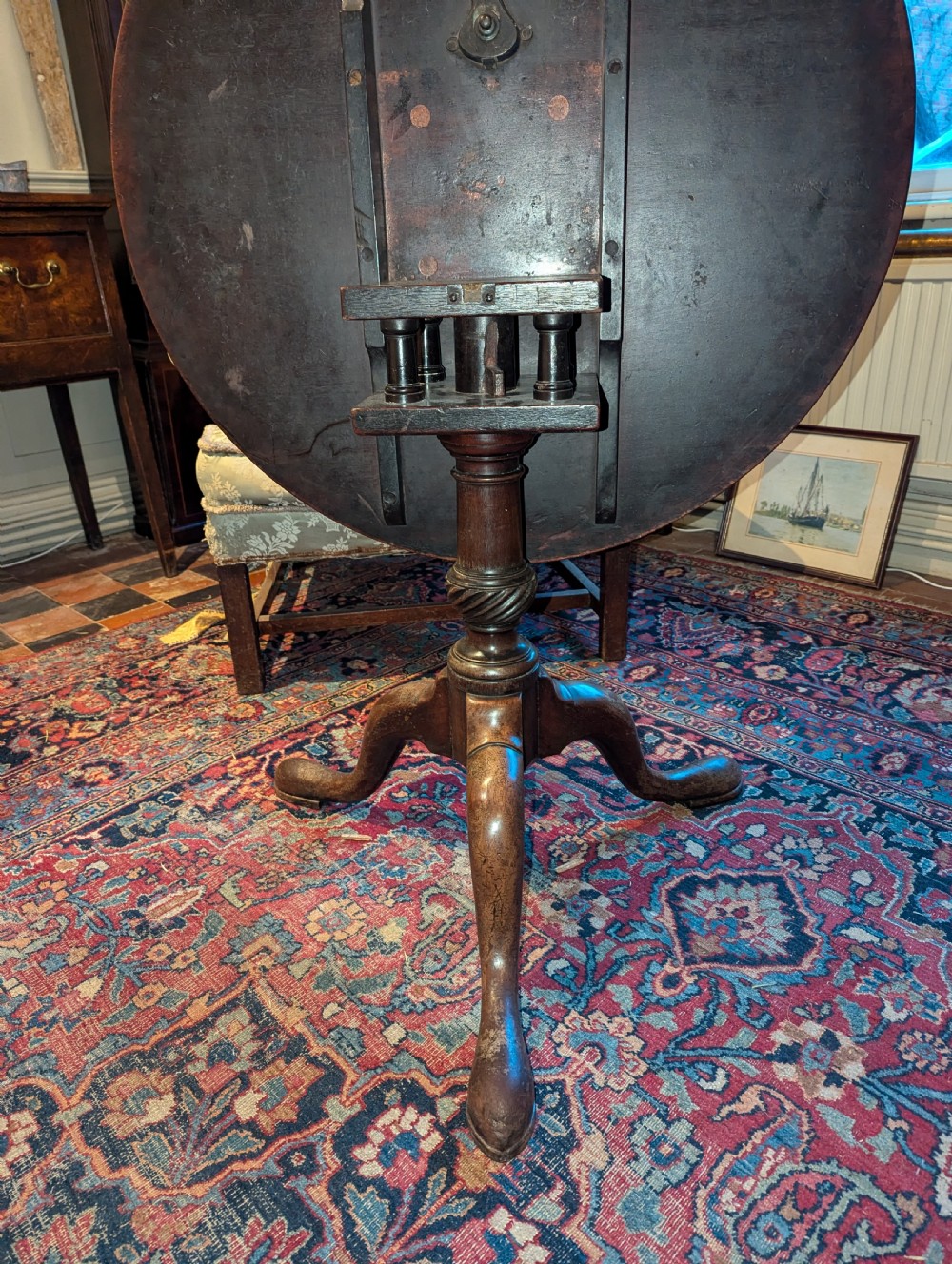 A George III mahogany tripod table featuring a circular top over a turned stem with a spiral collar and three cabriole legs. View II