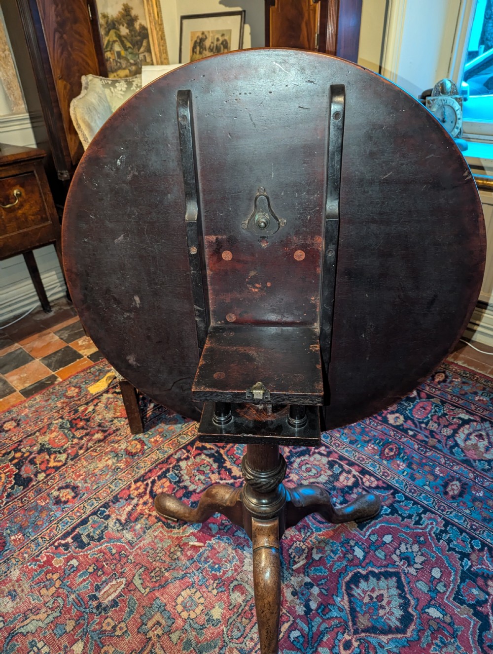 A George III mahogany tripod table featuring a circular top over a turned stem with a spiral collar and three cabriole legs. View III