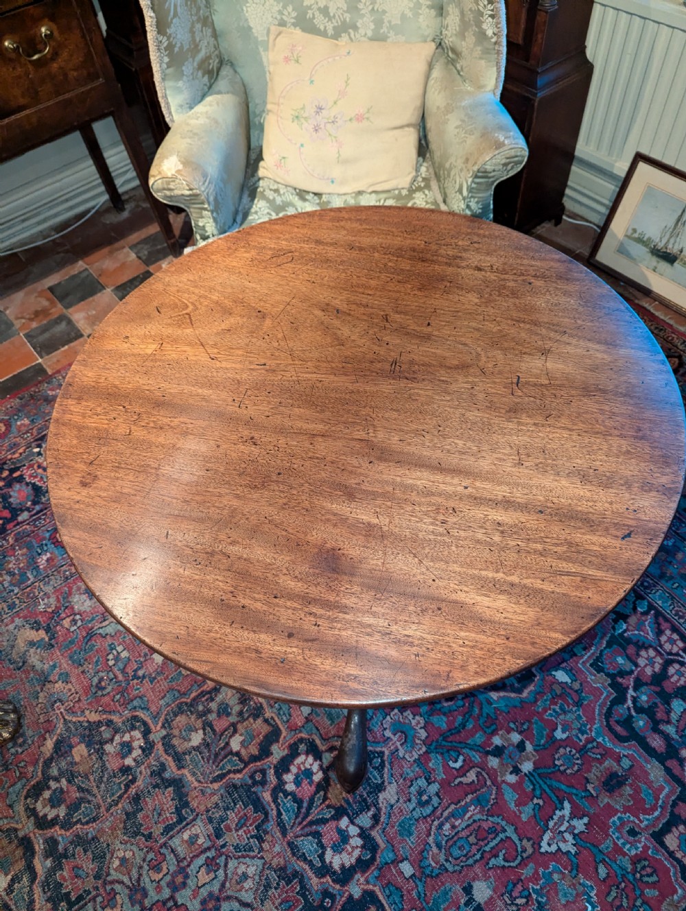 A George III mahogany tripod table featuring a circular top over a turned stem with a spiral collar and three cabriole legs. View V